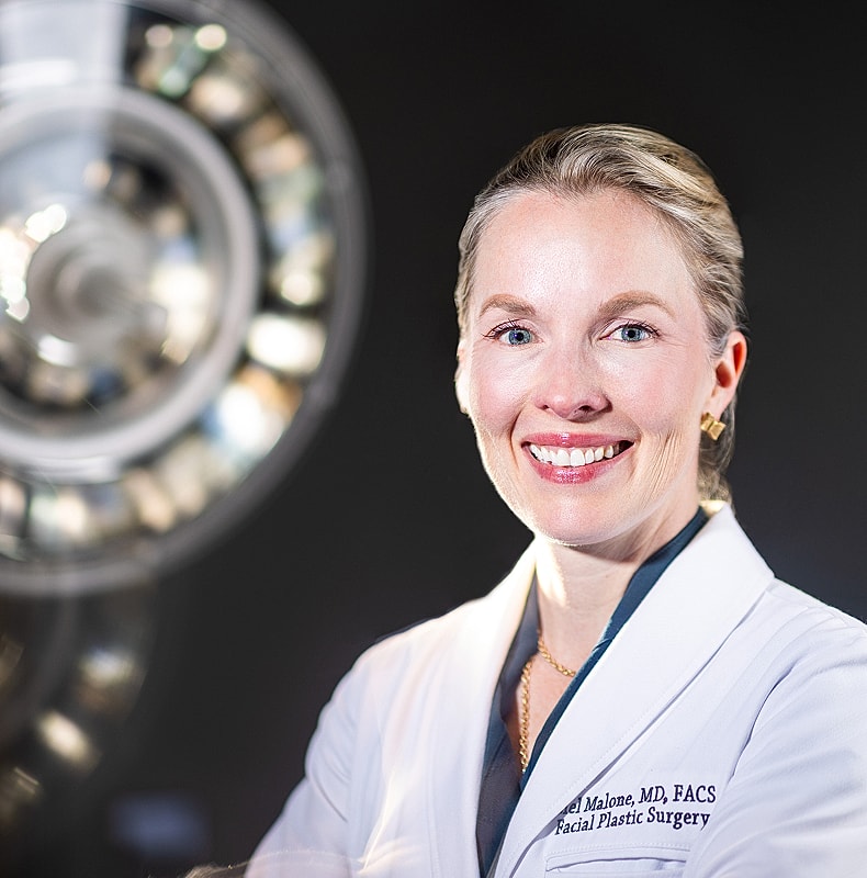 Female doctor smiling in surgical environment.