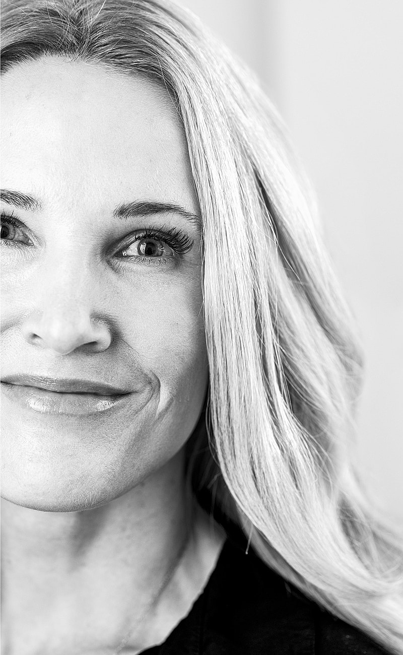 Black and white portrait of a smiling woman.