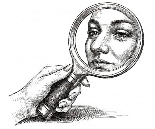 Hand holding magnifying glass reflecting woman's face