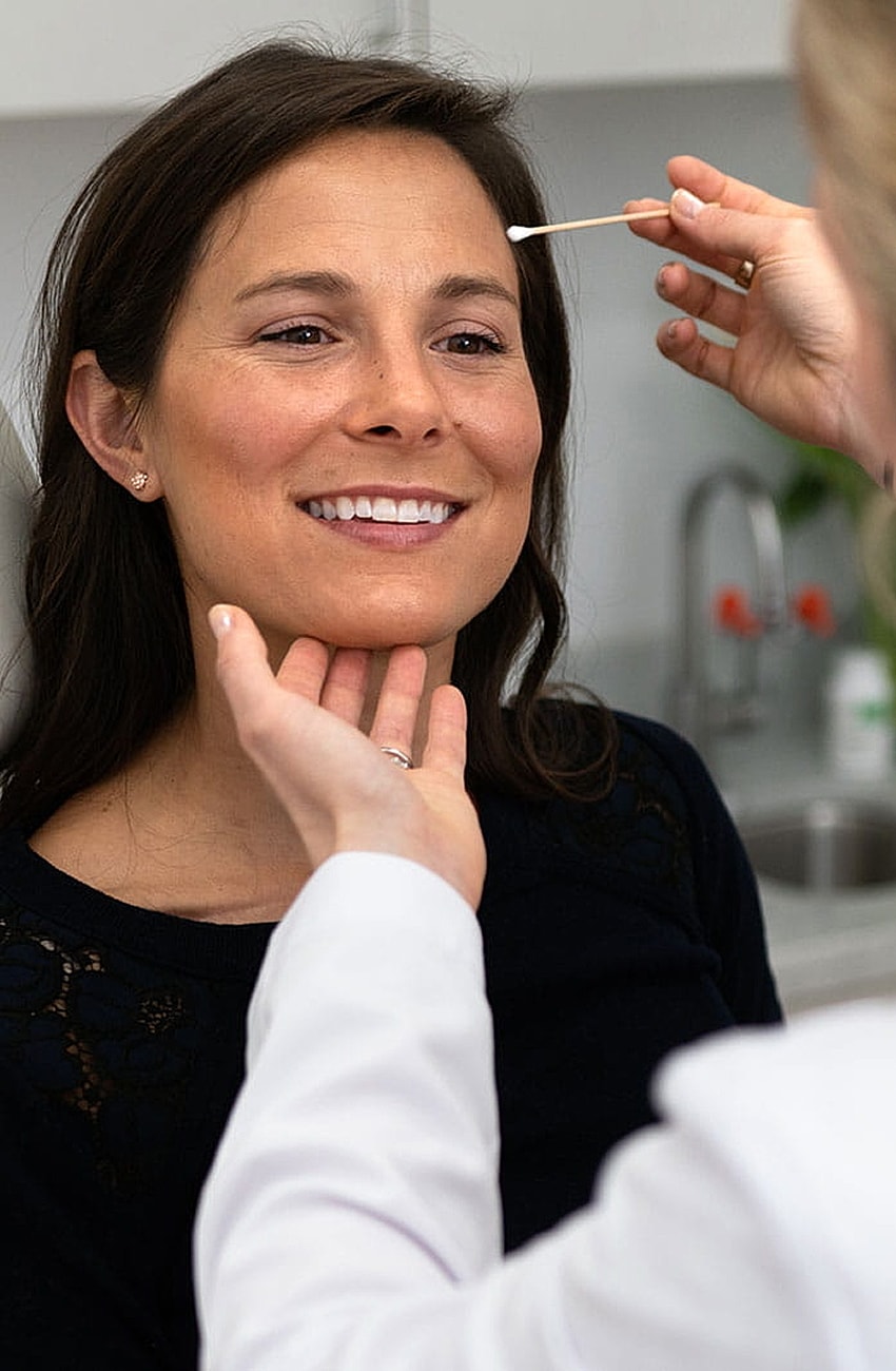 Woman receiving skincare treatment in clinic.