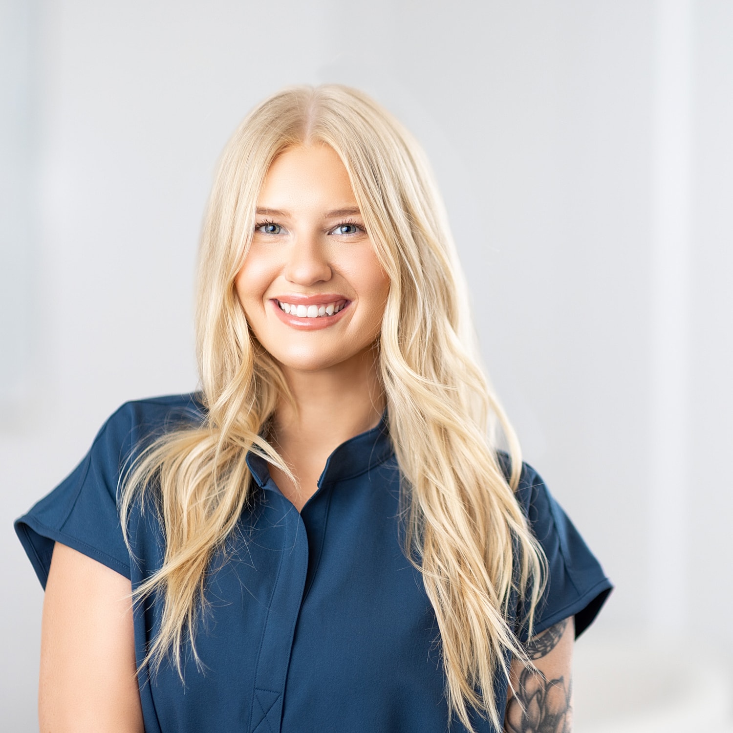 Smiling woman with long blonde hair, casual attire.