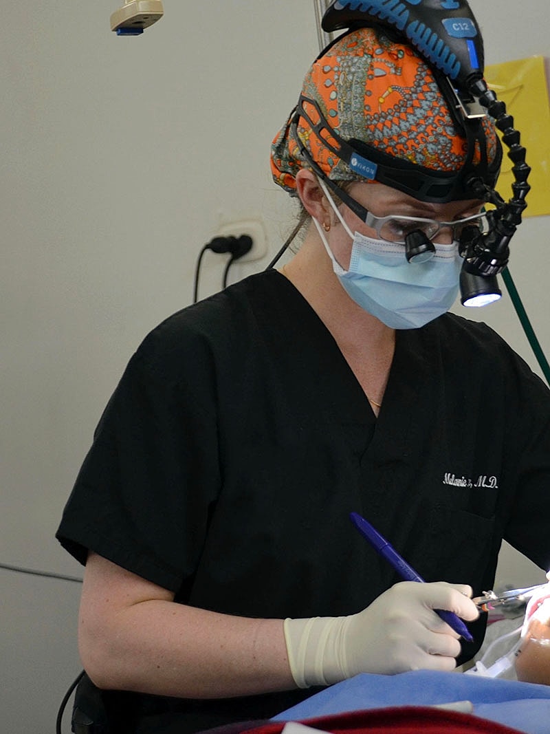 Dr Malone Facial Plastic Surgeon San DiegoSurgeon performing a procedure with focused concentration.