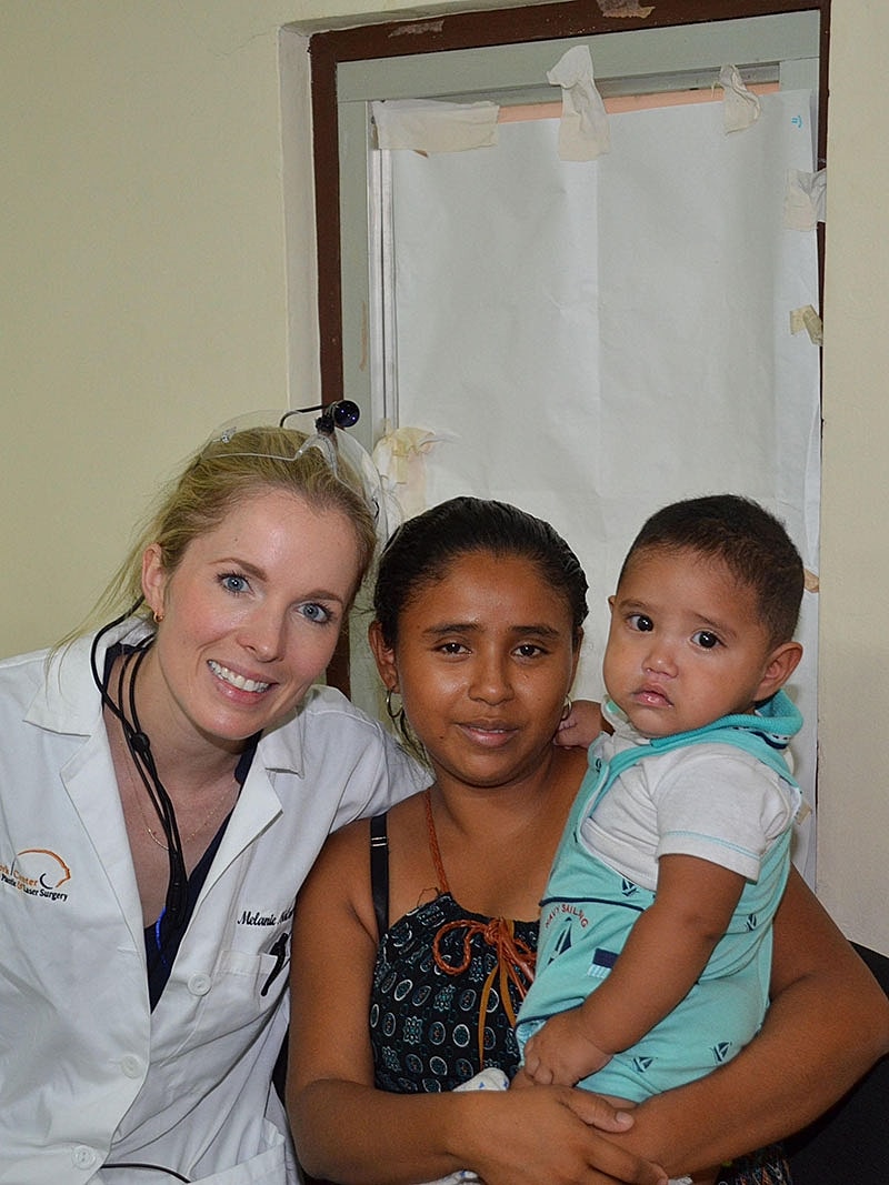 Dr Malone Facial Plastic Surgeon San DiegoDoctor with mother and child in clinic.
