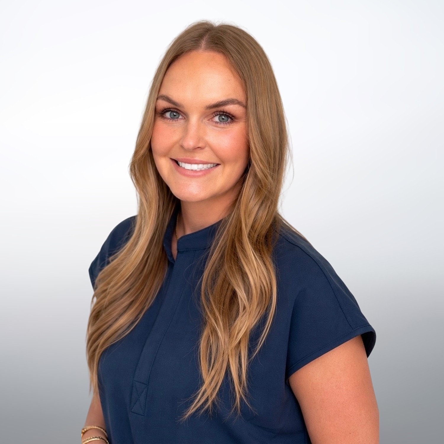 Smiling woman with long hair in navy shirt.
