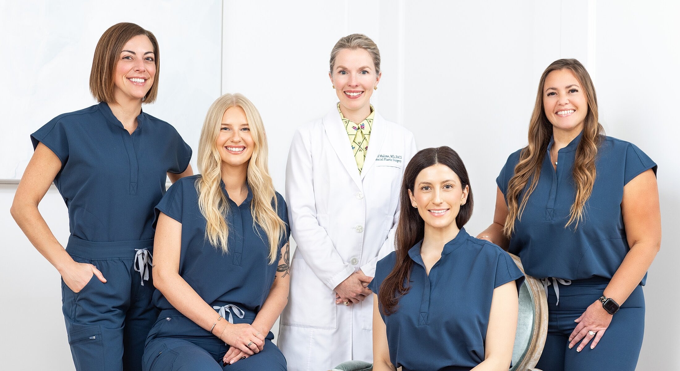 Medical team posing in clinic attire.