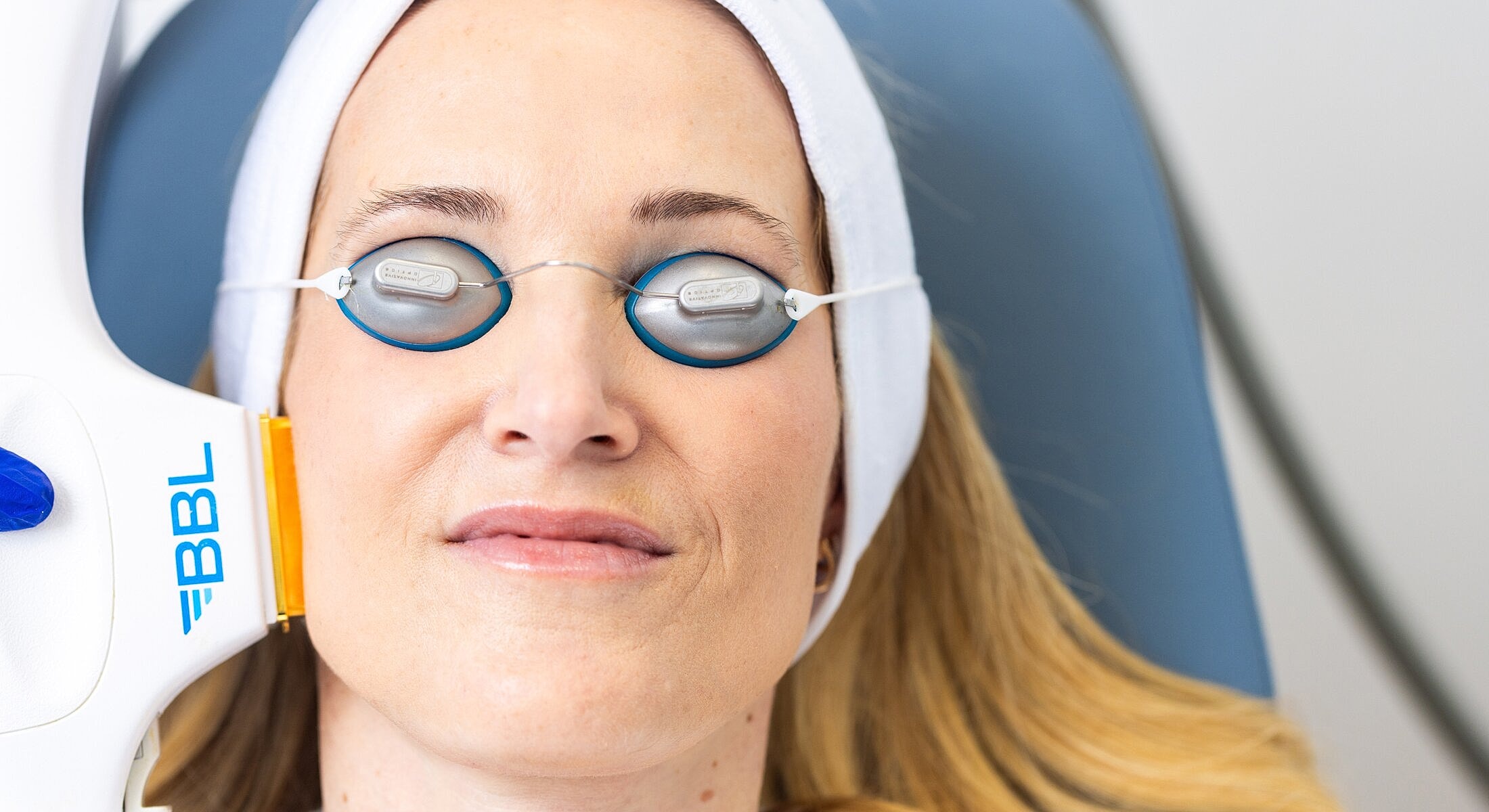 Woman receiving skin treatment with protective eyewear.