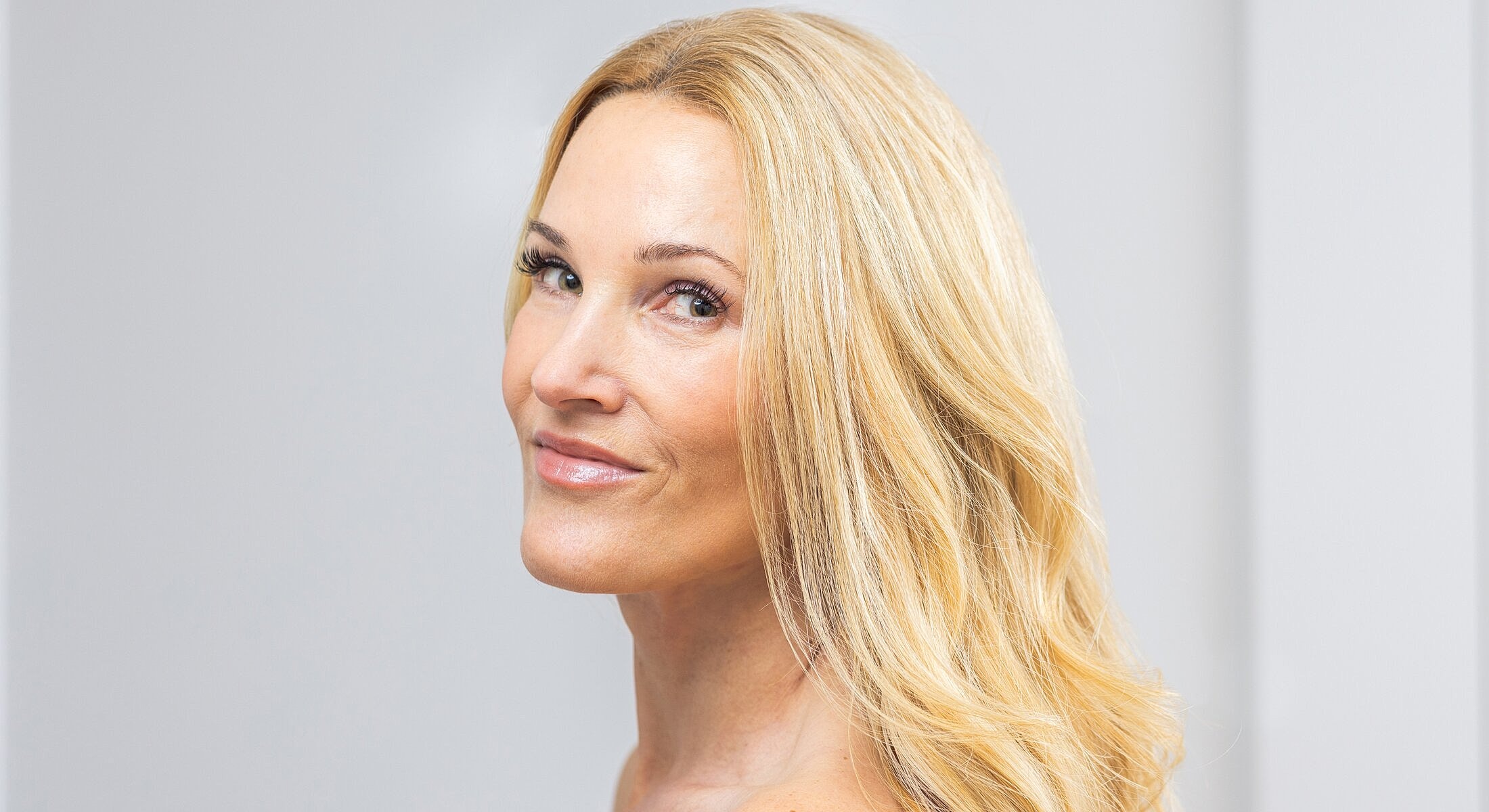 Smiling woman with long, wavy blonde hair.