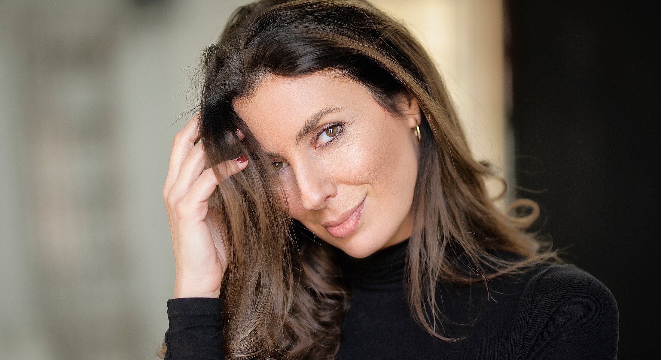 San Diego face and neck surgery model with long hair smiling playfully.