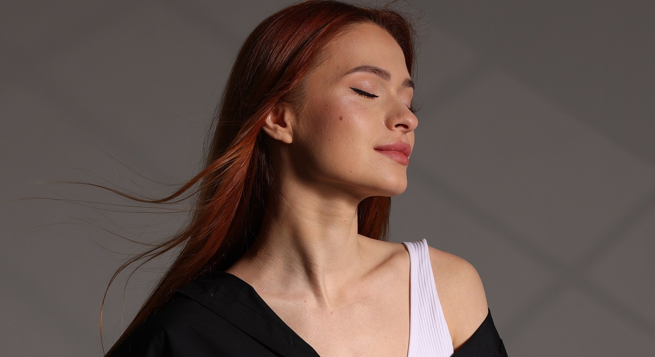 Woman with long red hair in soft lighting.