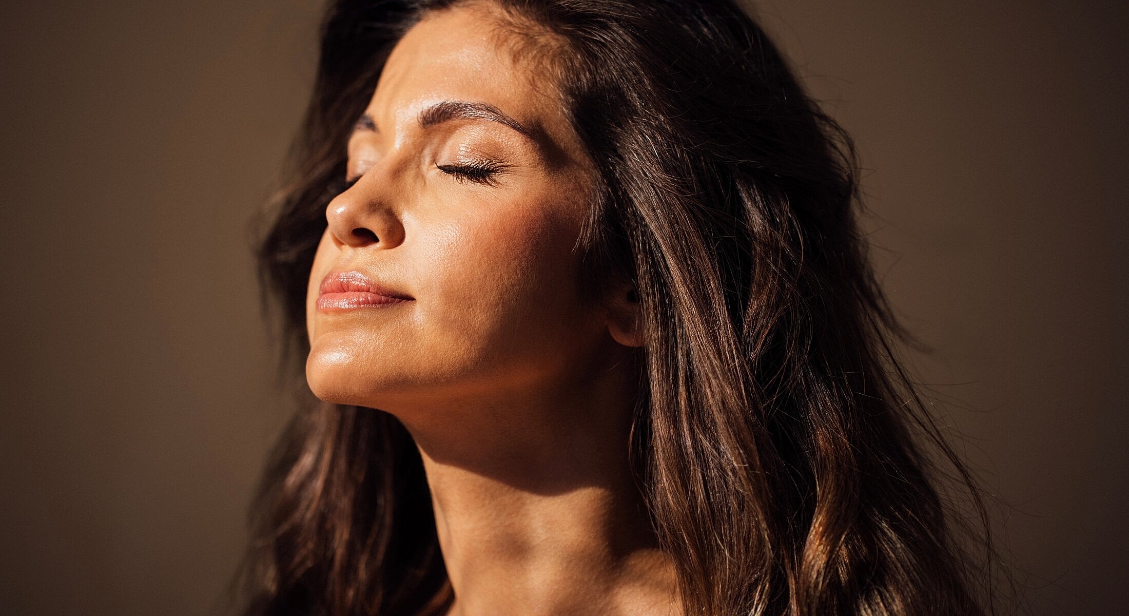 Woman enjoying sunlight with closed eyes.