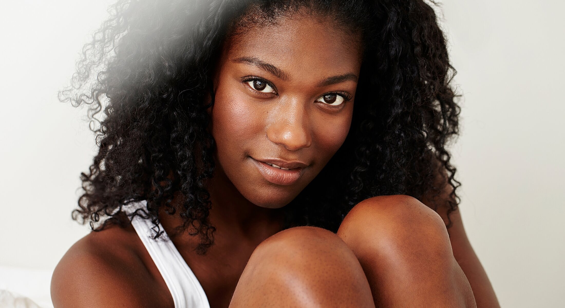 Smiling woman with curly hair looking at camera.