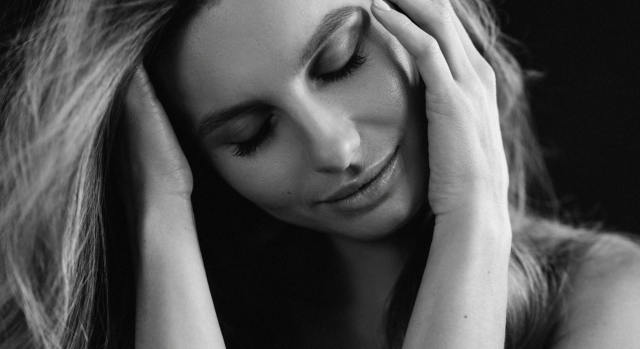 Woman with closed eyes, peaceful expression, black and white.